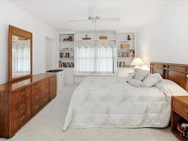 Primary bedroom with built-in bookcases.