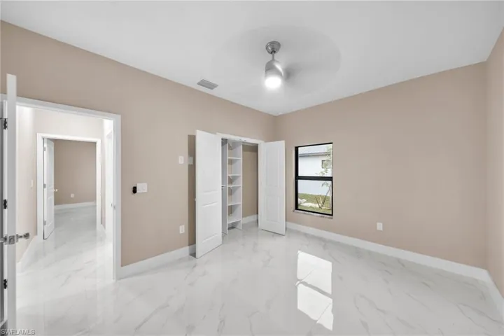 Unfurnished bedroom with ceiling fan and a closet