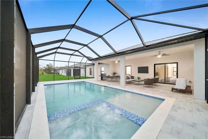 View of swimming pool with a patio area, ceiling fan, glass enclosure, and an outdoor hangout area