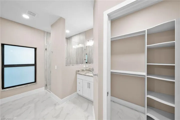 Bathroom featuring walk in shower and vanity