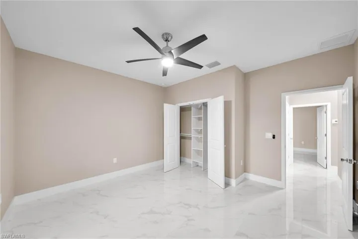Unfurnished bedroom with ceiling fan and a closet