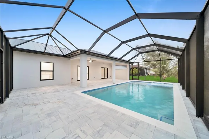 View of pool featuring a lanai, ceiling fan, and a patio