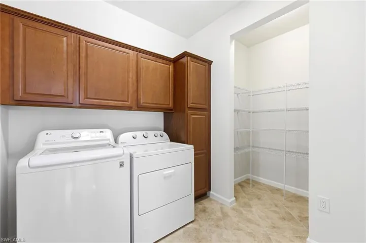 Laundry room with separate washer and dryer and cabinet space