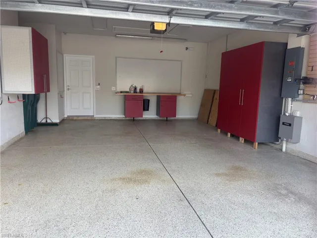 Garage featuring electric panel and a garage door opener