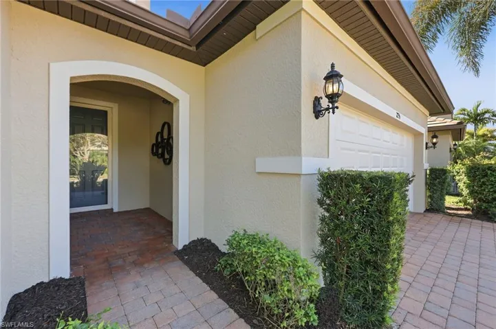 View of exterior entry featuring stucco siding and a garage
