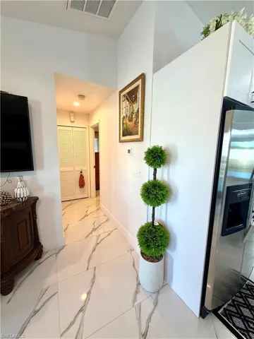Hallway with baseboards and light marble finish floors