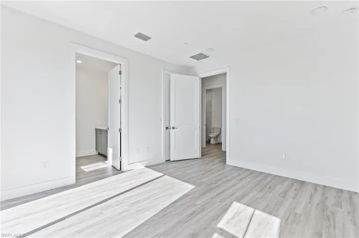 Unfurnished bedroom featuring light wood finished floors and ensuite bath