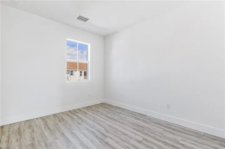 Spare room with wood finished floors and baseboards
