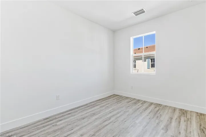 Spare room with baseboards and wood finished floors