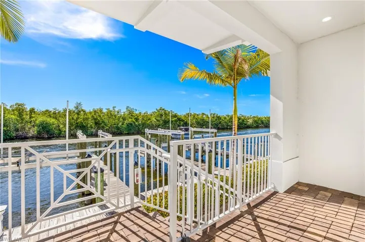 Balcony featuring a water view, boat lift, and a boat dock