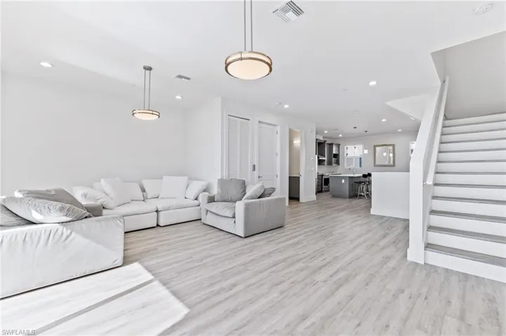 Living room featuring stairway, recessed lighting, and light wood finished floors