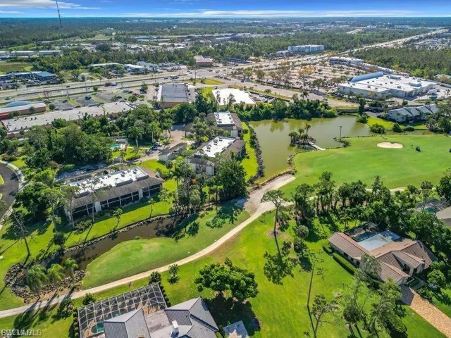 Aerial view of property's location with a nearby body of water and a golf course