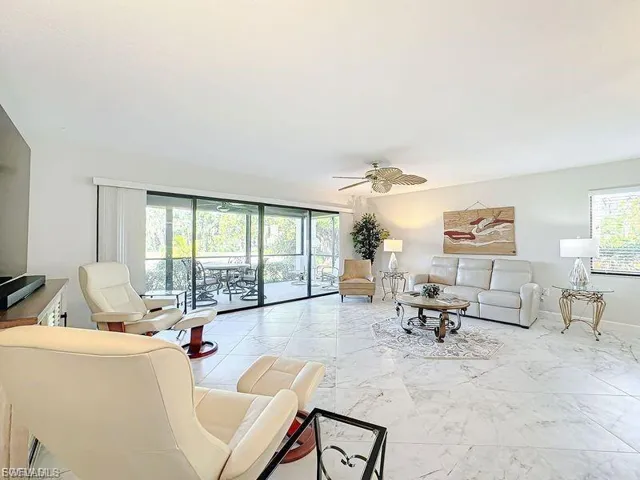 Living area with a ceiling fan and marble finish flooring