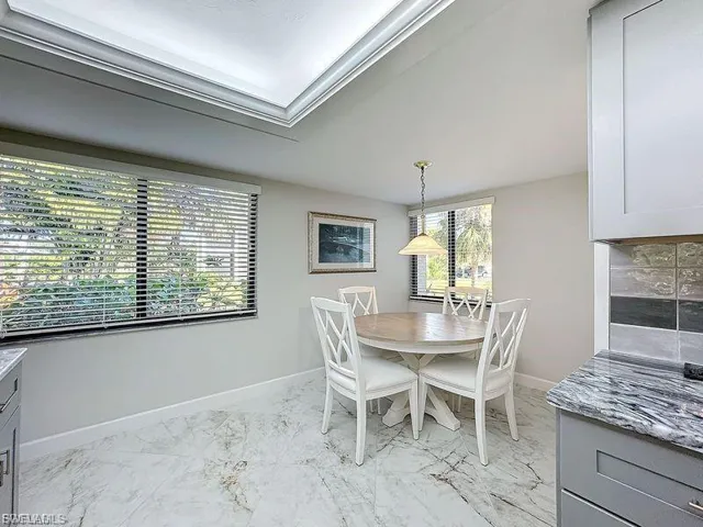 Dining area with light marble finish flooring and baseboards