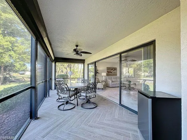 Sunroom / solarium with outdoor dining space, healthy amount of natural light, and a ceiling fan