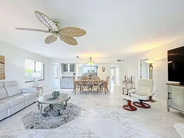 Living area with baseboards and ceiling fan