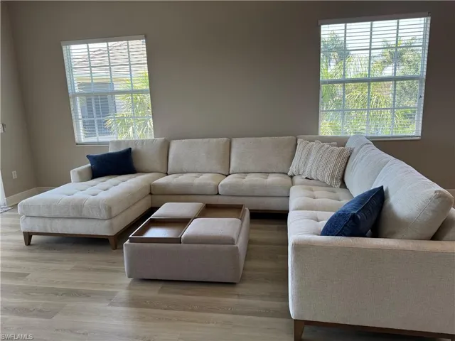 Living area featuring light wood-style floors, baseboards, and a wealth of natural light