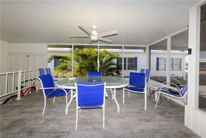 Sunroom / solarium featuring outdoor dining area, a ceiling fan, and a patio area