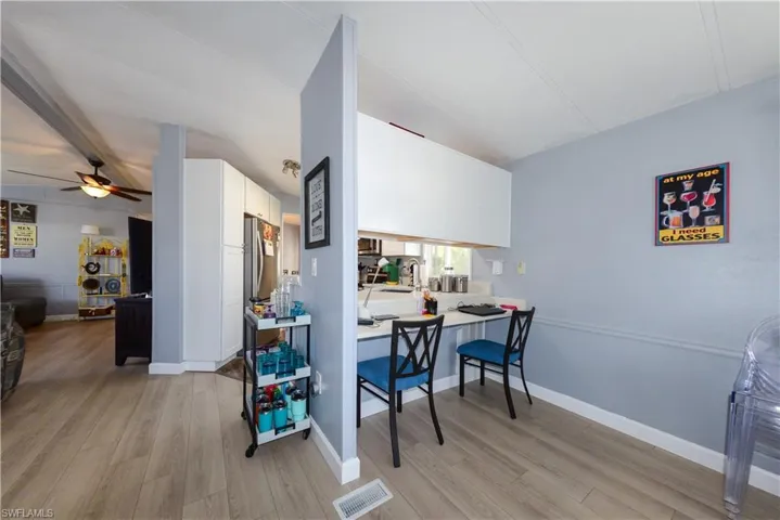 Dining room featuring light wood-style flooring, ceiling fan, and beam ceiling