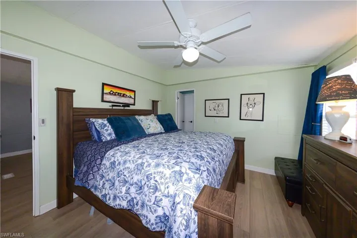 Bedroom featuring wood finished floors, a ceiling fan, and vaulted ceiling