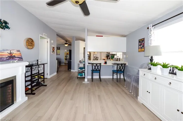 Living area featuring ceiling fan, light wood-style flooring, and a fireplace