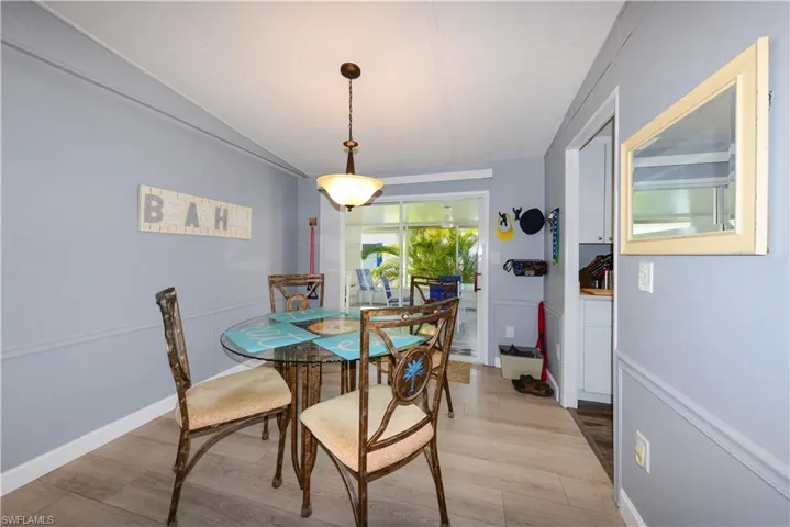 Dining space featuring light wood finished floors and vaulted ceiling