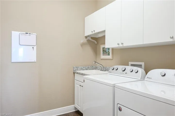 Laundry area with cabinets, laundry tub and washer/dryer