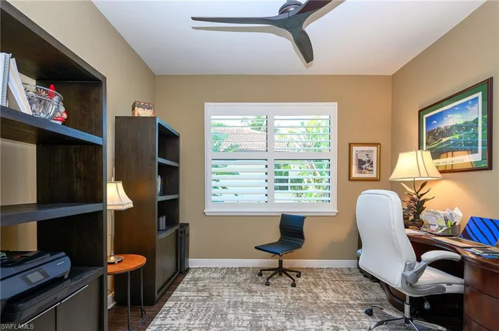 Office area with a ceiling fan and baseboards