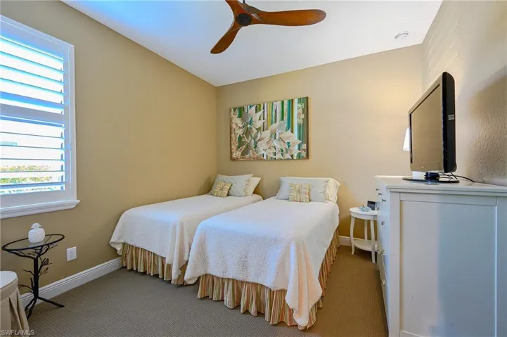 Carpeted bedroom featuring baseboards and ceiling fan