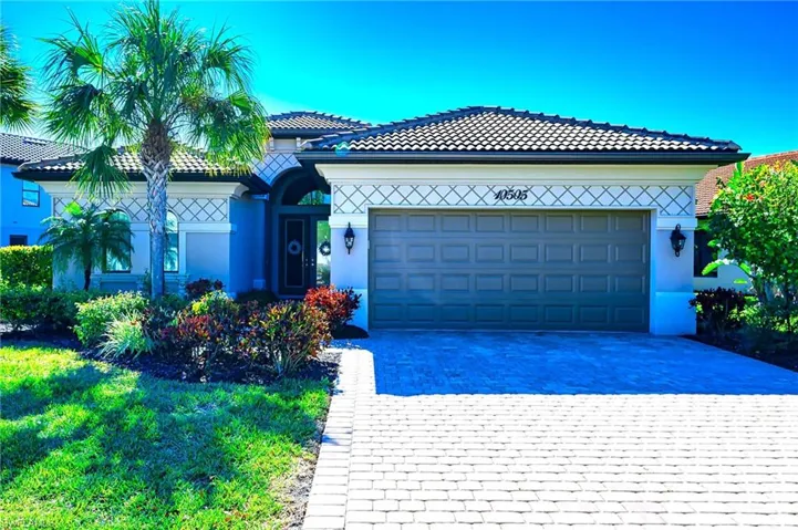 Ranch-style house with decorative driveway, a garage, and stucco siding