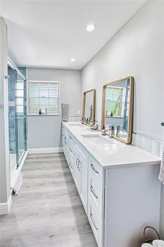 Bathroom featuring double vanity, a stall shower,