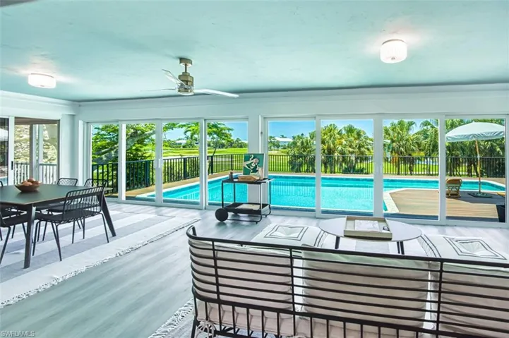 Sun room with view of pool and golf course. Extra open area for entertaining.