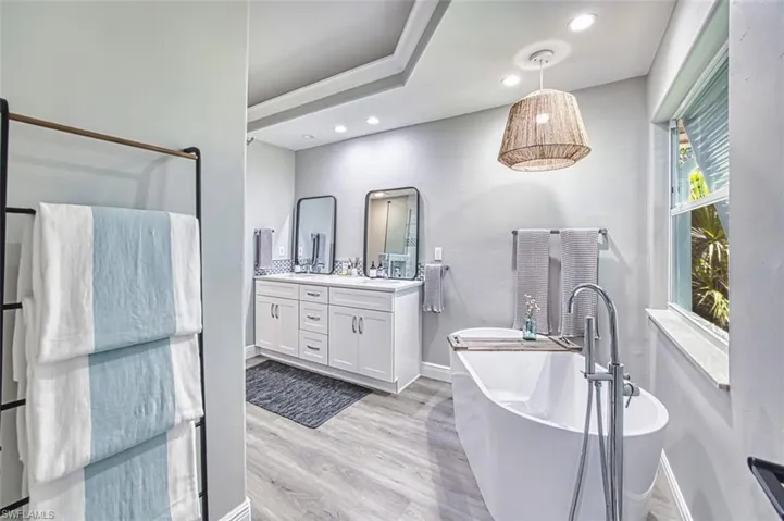 Full bathroom with double vanity, recessed lighting,a freestanding tub,