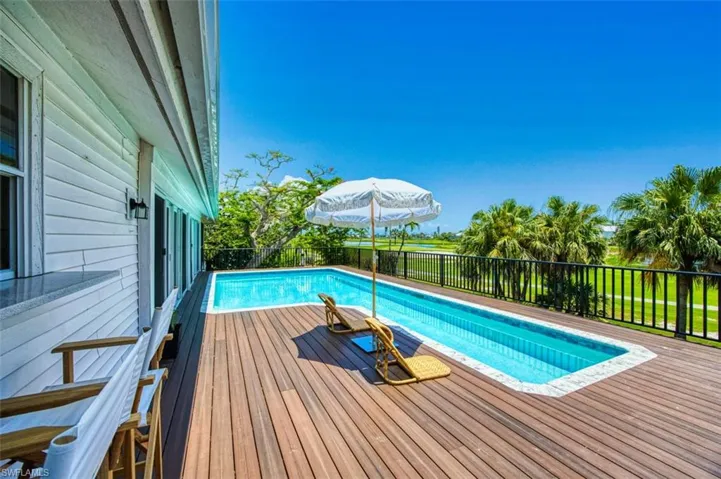 View of swimming pool with a wooden deck, raised