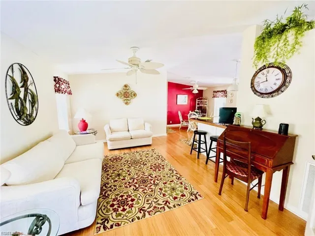 Open concept living area featuring solid bamboo wood flooring, a ceiling fan, and a pass-through counter
