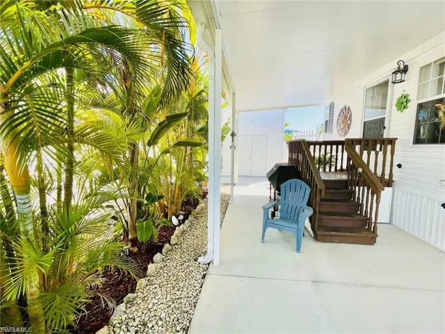 Covered outdoor patio with a staircase leading to an elevated entrance