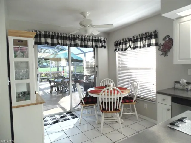 Dining area featuring a sunroom, a ceiling fan, and light tile patterned flooring