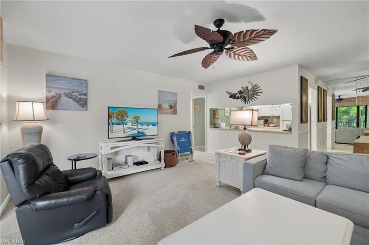 Living room with light colored carpet and ceiling fan