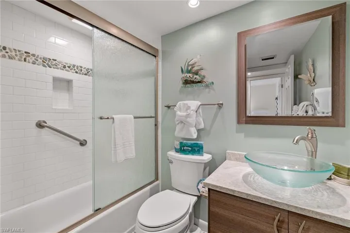 Full bath featuring vanity and shower / bath combination with glass door