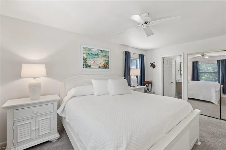 Carpeted bedroom featuring a ceiling fan and a closet
