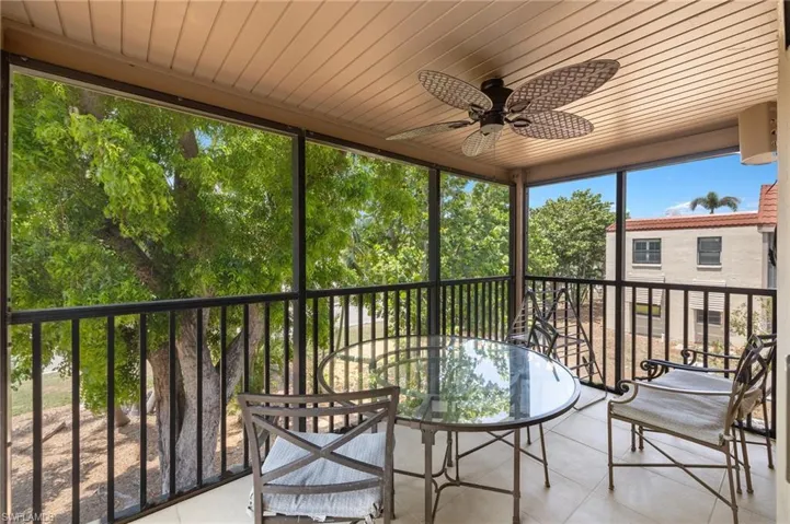 Sunroom / solarium with a ceiling fan and outdoor dining space