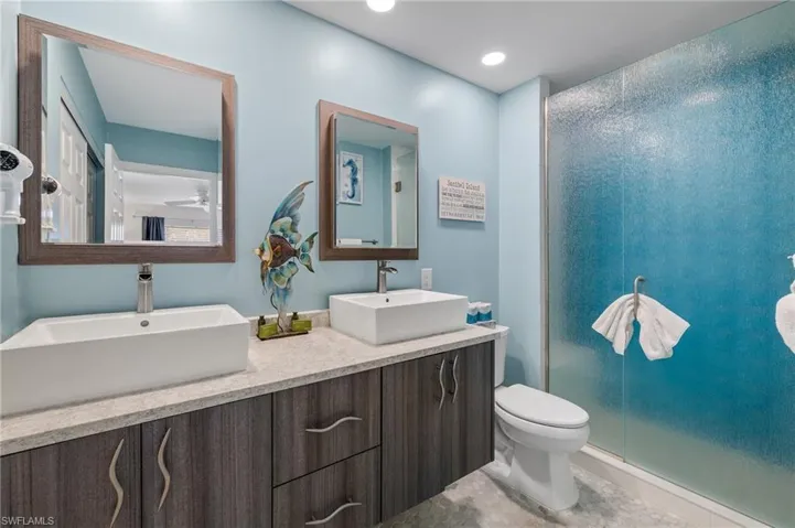 Bathroom featuring double vanity, ceiling fan, and recessed lighting