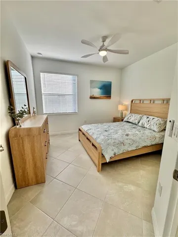 Bedroom with access to exterior, a raised ceiling, and ceiling fan