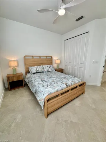Bedroom with a raised ceiling, and ceiling fan