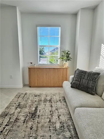 Den featuring tile patterned flooring and baseboards