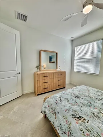 Bedroom with a raised ceiling, and ceiling fan