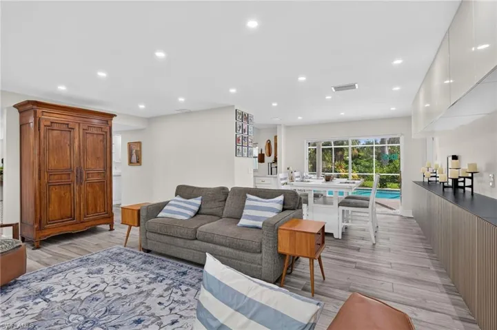 View from the living room through the dining area and sliders to the pool area beyond.