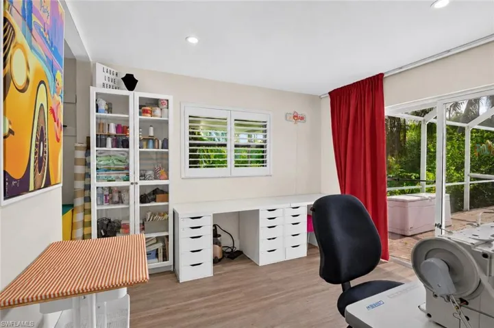 Fourth bedroom, set up as sewing/hobby room, sliders to pool area.