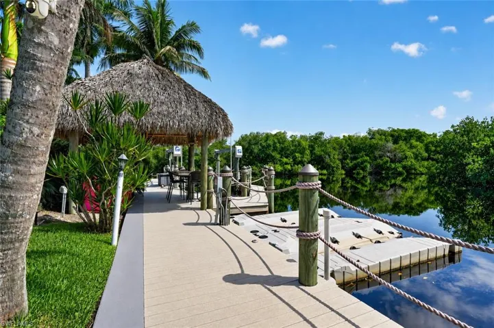 Dock walkway leading to large lift, jet-ski docks, and Tiki hut.