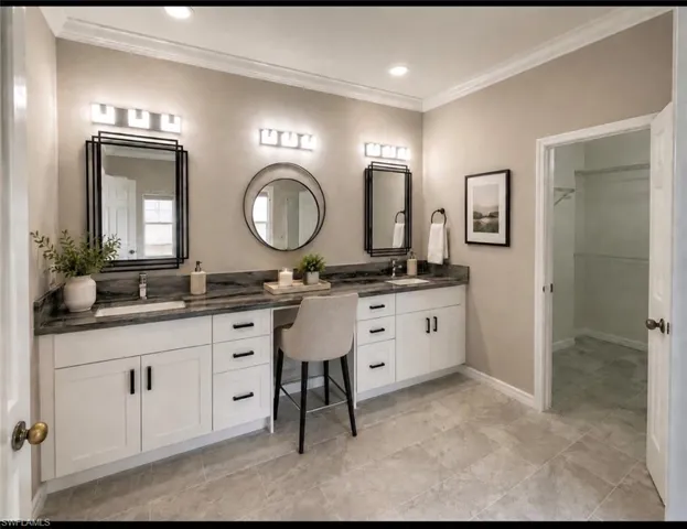 Dual vanity featuring undermount sinks, dark stone countertops, and ample storage cabinetry